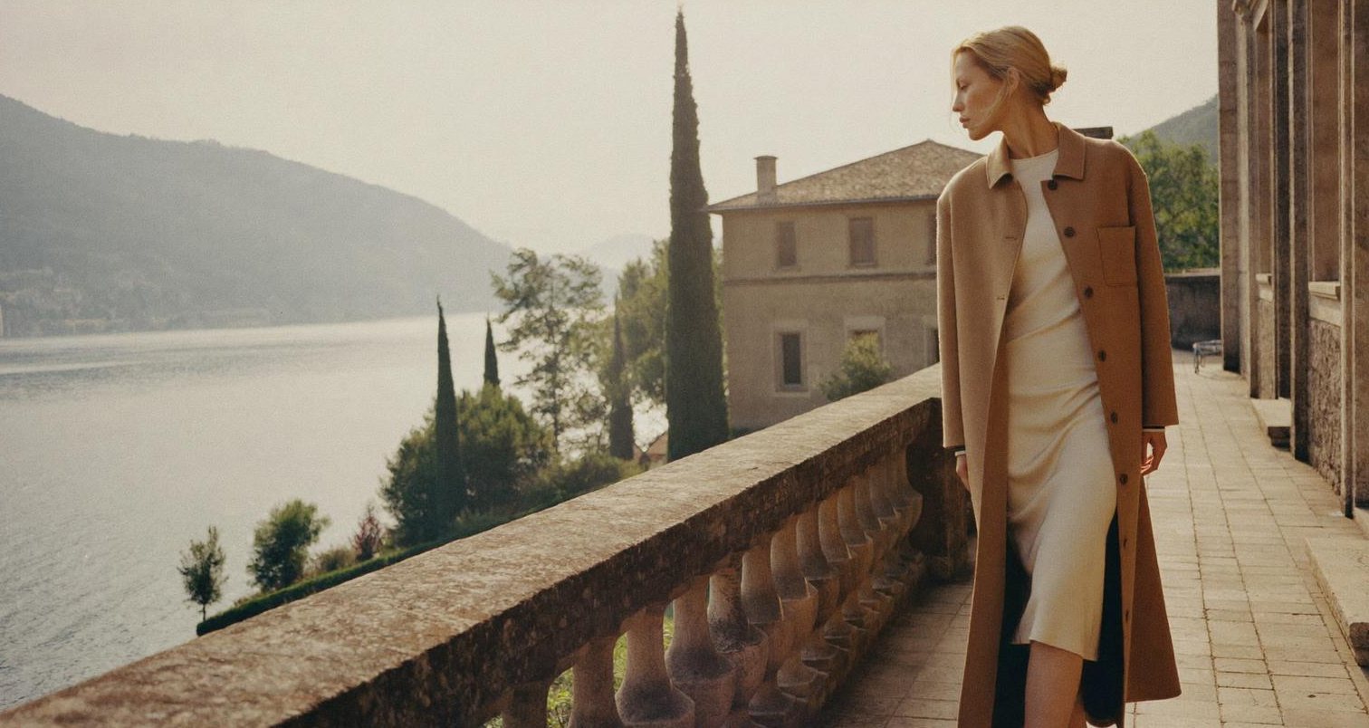 Model in a camel coat on a villa terrace above Lake Como